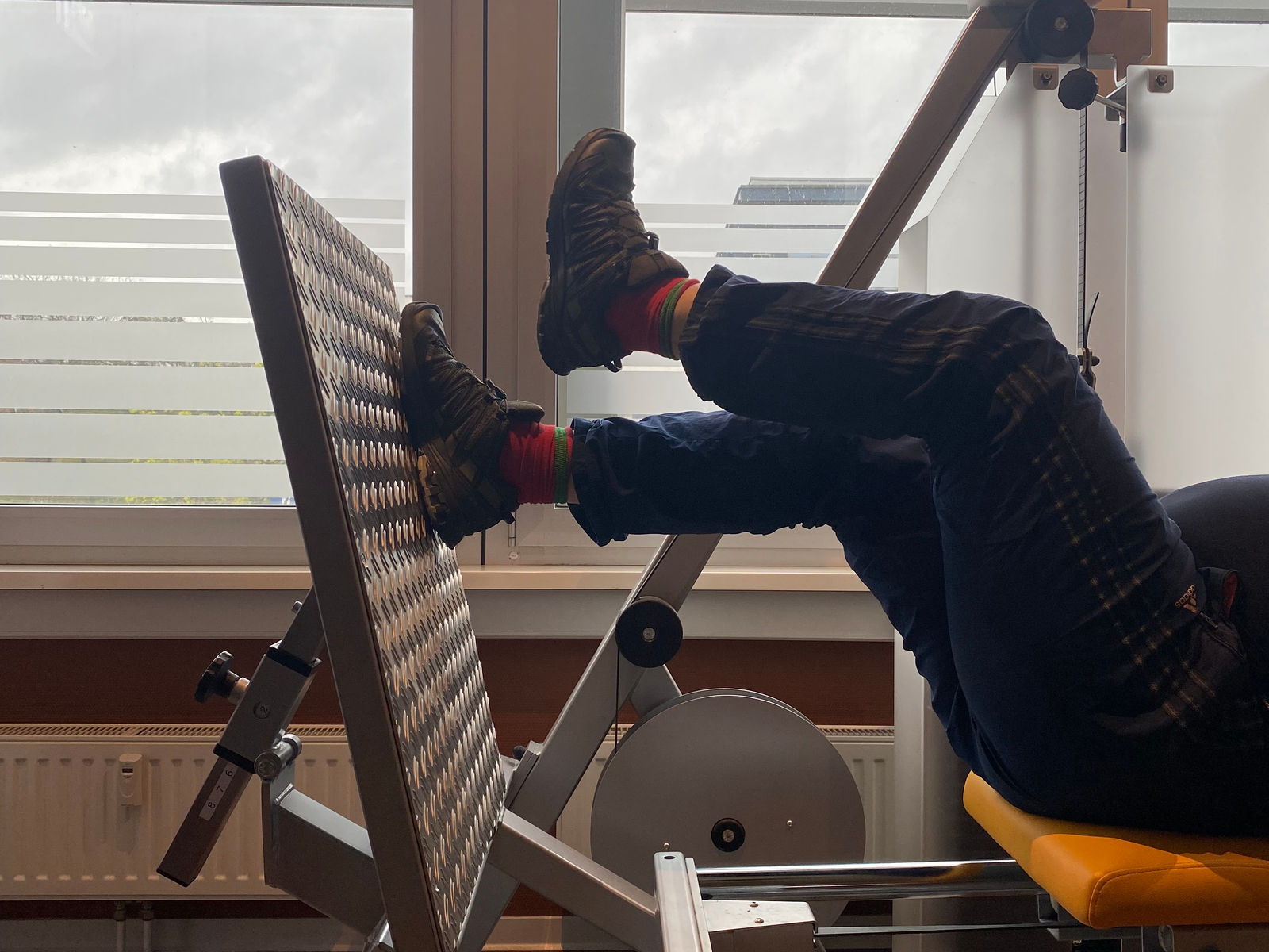 Patient an einem Beinpress-Gerät im Turnraum